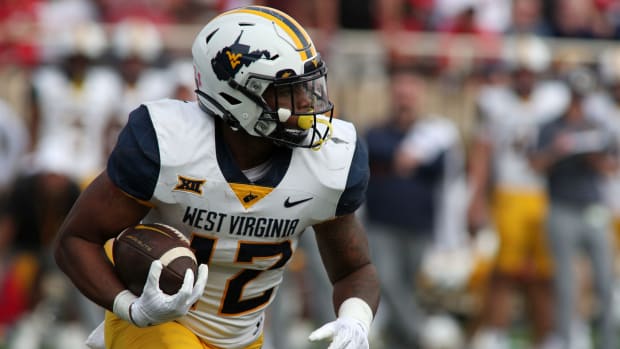 Oct 22, 2022; Lubbock, Texas, USA; West Virginia Mountaineers running back CJ Donaldson (12) rushes against the Texas Tech Red Raiders in the second half at Jones AT&T Stadium and Cody Campbell Field. Mandatory Credit: Michael C. Johnson-USA TODAY Sports